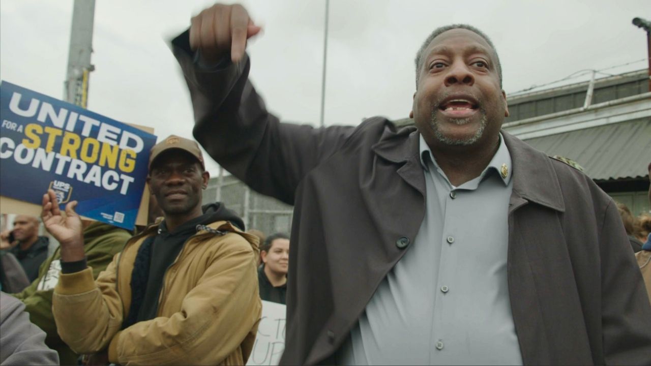 a man pointing down next to another man